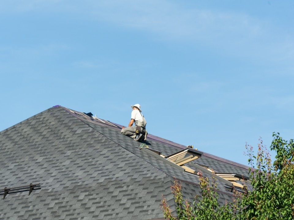 człowiek naprawiający dach